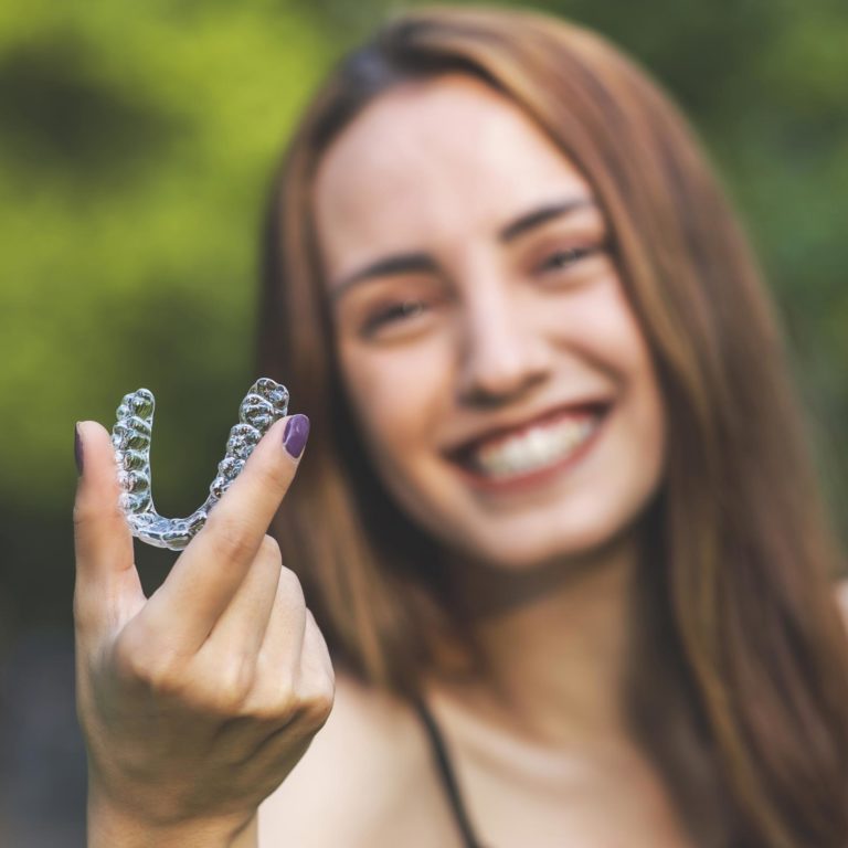woman holding clear aligners in Slave Lake