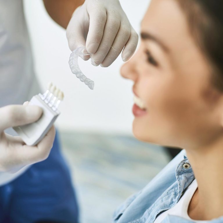 dentist handing Invisalign to patient at our dental clinic in Slave Lake